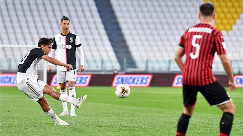 Dybala remata ante la mirada de Cristiano Ronaldo.