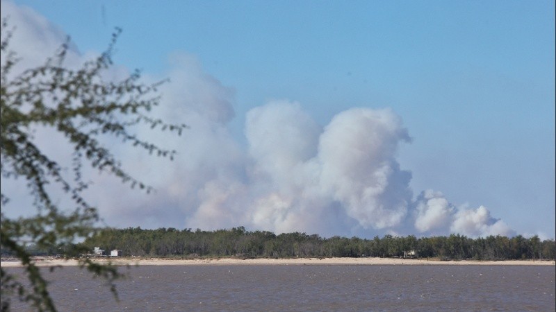 Los focos de incendio levantan densas columnas de humo que cruza el río.