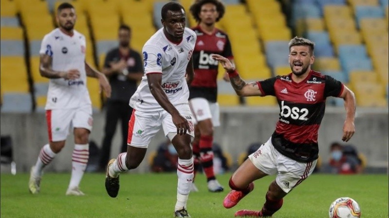 Giorgian De Arrascaeta de Flamengo disputa el balón con Felipe Dias, de Bangú.