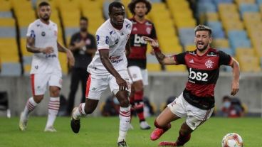 Giorgian De Arrascaeta de Flamengo disputa el balón con Felipe Dias, de Bangú.