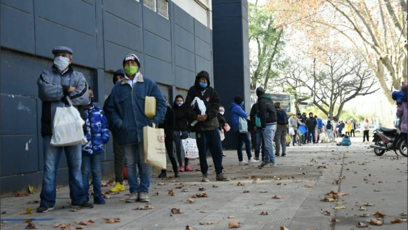 Larga fila en Arroyito para recibir empanadas y locro.