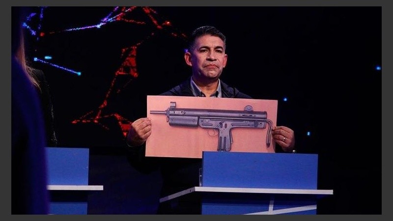 Su foto más famosa, cuando mostró el arma que mató a su hijo en el debate para concejal.