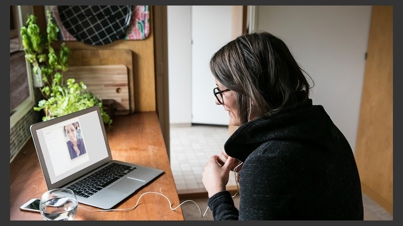 Side view of businesswoman video calling female colleague on laptop in home office