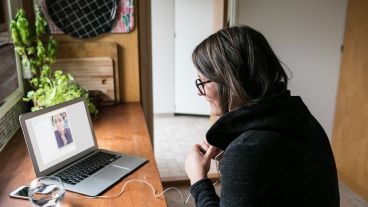Side view of businesswoman video calling female colleague on laptop in home office