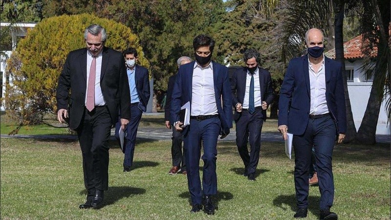 La comitiva liderada por el presidente llegando a Olivos para los anuncios. 