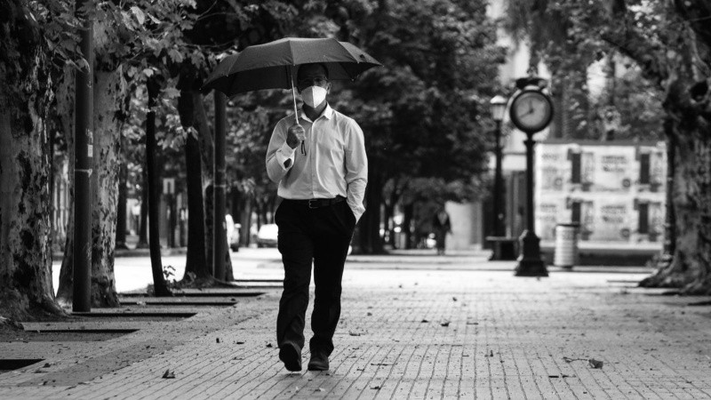 Un hombre camina por plaza San Martín en este viernes de cuarentena y lluvia.