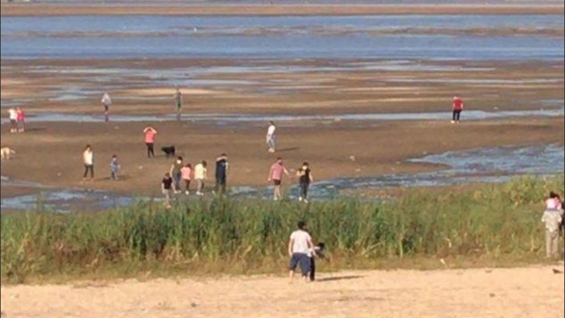 Mucbas personas intentan cruzar la laguna caminando ante la bajante de las aguas. 