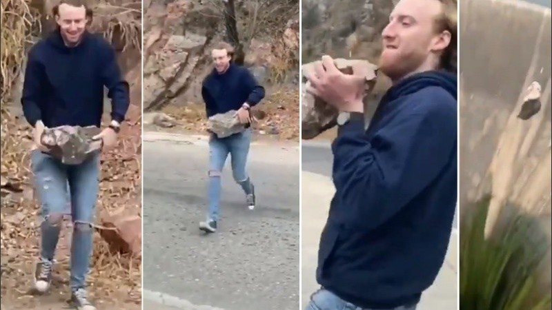 El joven toma la piedra y la arroja al embudo mientras se rié. 