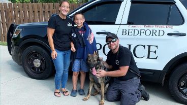 Brady Snakovsky junto a su madre, un policía y un perro vistiendo uno de los chalecos donados.