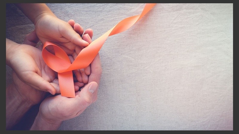Adult and child hands holding orange Ribbons,  Leukemia cancer awareness and Multiple sclerosis awareness, panoramic banner