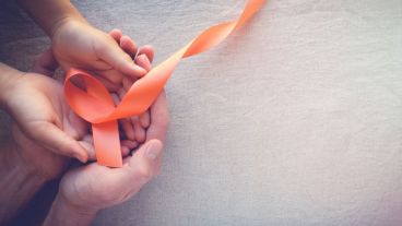 Adult and child hands holding orange Ribbons,  Leukemia cancer awareness and Multiple sclerosis awareness, panoramic banner