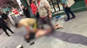 El ladrón atrapado, con sangre en la cara contra el piso y desnudo.