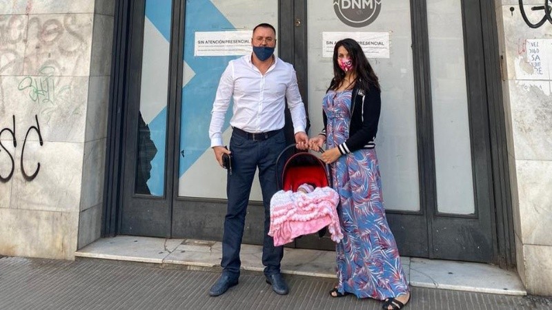 Viktor junto a su mujer y su flamante hija frente a la sede de Migraciones en Rosario