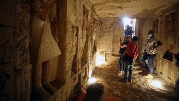 La apertura de un sarcófago con mucha gente alrededor.