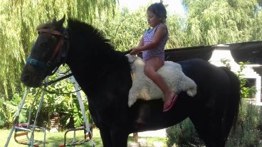 Pochola con una de las niñas de la casa, que ahora espera su regreso.