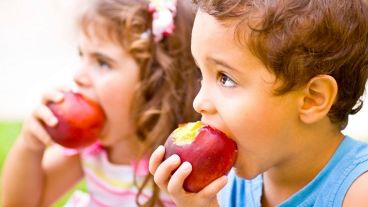 Happy children eating apple