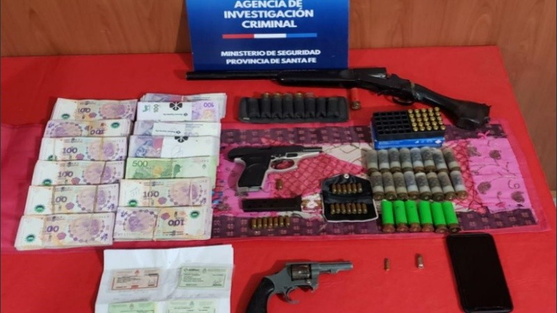 Dinero y armas encontradas durante los procedimientos.