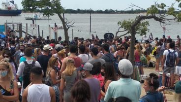 Rosarinos y rosarinas esperan cruzar el río.