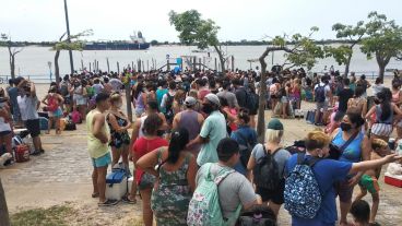 Rosarinos y rosarinas esperan cruzar el río.