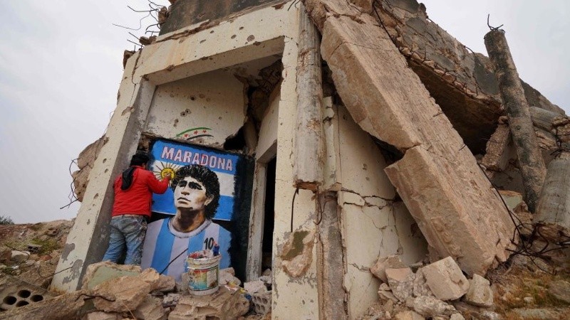 Maradona con la 10 y la celeste y blanca en los restos de una casa destruida en Binnish.