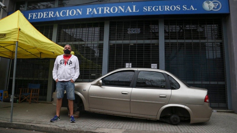 José Luis con su auto sin ruedas apostado en la puerta de la aseguradora desde ayer. 