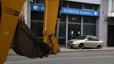 La retroexcavadora y el auto en la puerta de la aseguradora.
