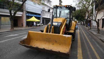 La retroexcavadora y de fondo José Luis con su auto sin ruedas: toda una postal.
