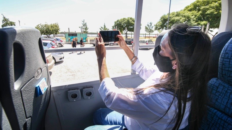 Una mujer toma una foto del río en la costa central rosarina.