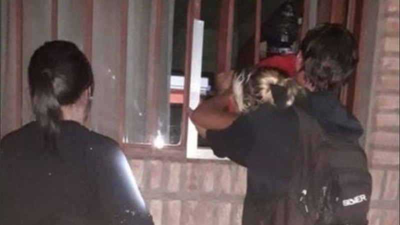 El momento en que la joven es retirada de la reja por los bomberos. 