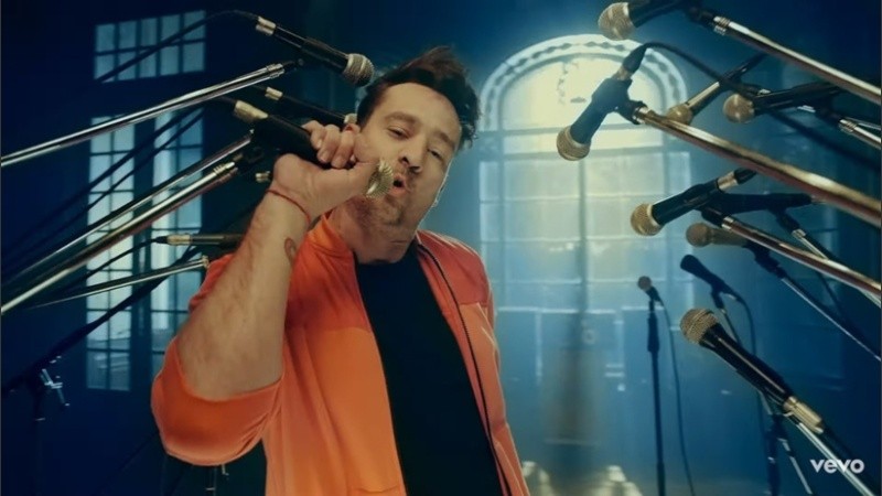 Imágenes del videoclip, el cantante se lo ve rodeado por enjambres de micrófonos.