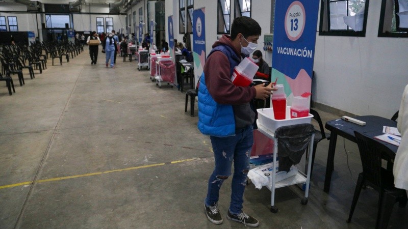 Un joven reparte bien temprano los materiales para llevar adelante la jornada de vacunación.