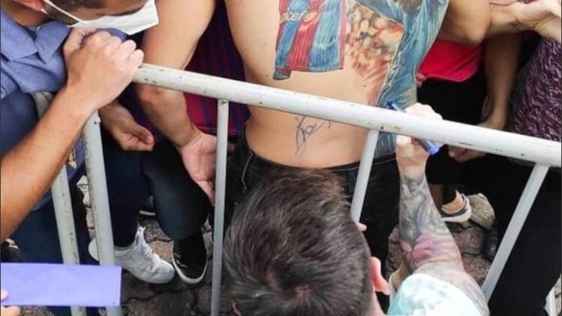 El momento en que Messi firmó la espalda del fan. 