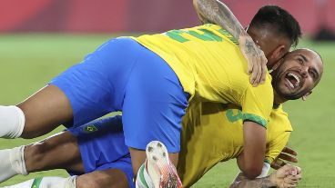 Dani Alves es abordado por sus compañeros en pleno festejo de la medalla de oro.