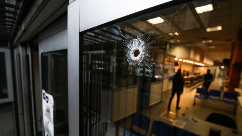 El impacto de bala en el vidrio de la puerta principal. 