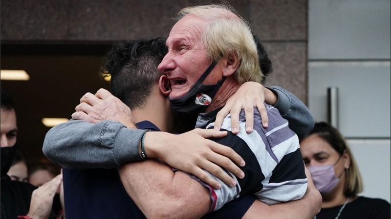 El padre del kiosquero asesinado abrazando a su nieto durante el velorio.