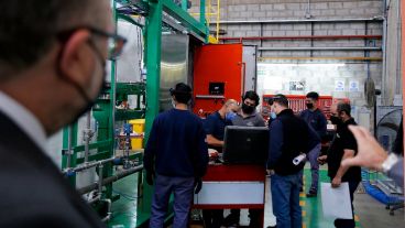 Kulfas observa a un grupo de trabajadores de una pyme en su última recorrida.