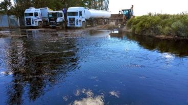 Camiones trabajando para retirar los restos de petróleo en la zona afectada.