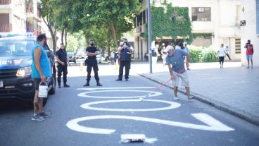 Mono Saavedra pinta frente a Tribunales ante la mirada de policías.