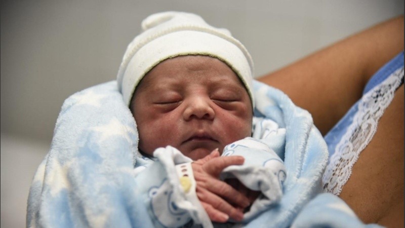 Lionel descanza en los brazos de su madre tras haber sido el primer rosarino en nacer durante el 2022.