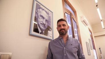 Enrique junto a un retrato de su padre Guillermo, cofundador del Partido Socialista Popular