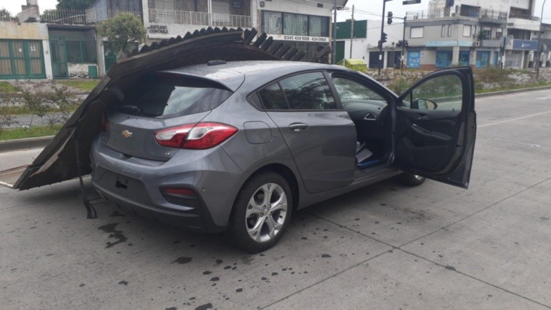 El auto robado en el predio y el portón derrumbado.