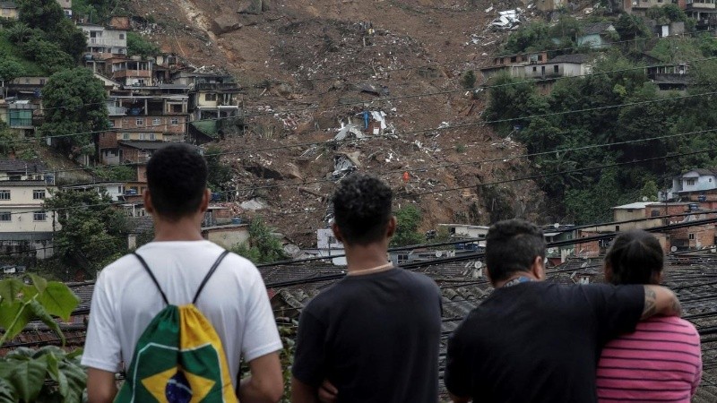 Varias personas observan la destrucción tras las fuertes lluvias del martes en el Morro de la Oficina, hoy, en la ciudad de Petrópolis, estado de Rio de Janeiro