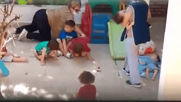 La mujer empujando a uno de los niños en el patio del jardín