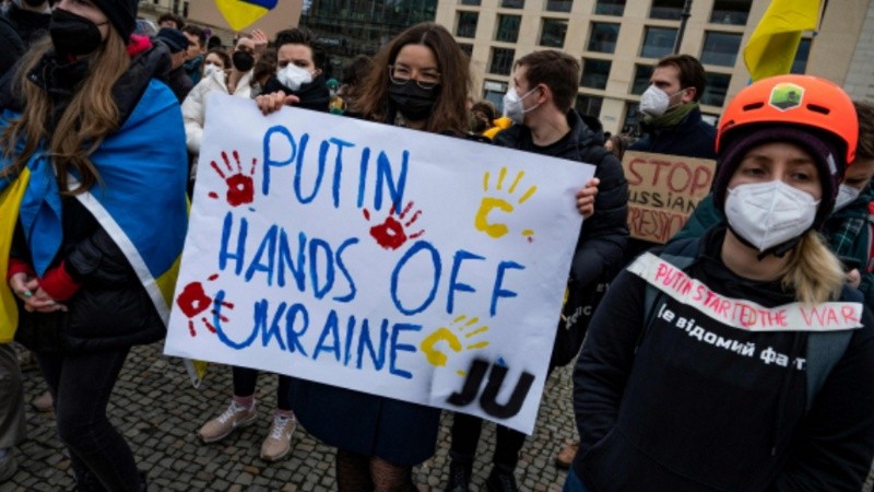 Los manifestantes exhiben pancartas durante una protesta contra la invasión rusa de Ucrania frente a la Puerta de Brandenburgo en Berlín.