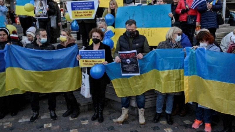 Los ucranianos que viven en Grecia sostienen banderas y pancartas nacionales durante una manifestación en el centro de Atenas.
