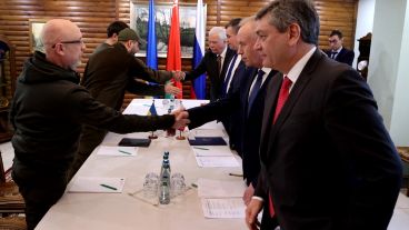 Miembros de las delegaciones rusa (derecha) y ucraniana (izquierda)  durante las negociaciones del alto el fuego entre ambos países.