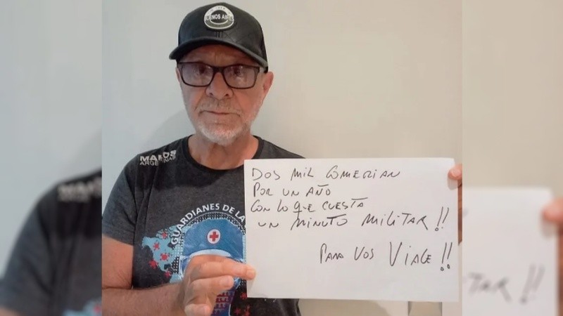 Gieco sostiene un cartel que reza: 