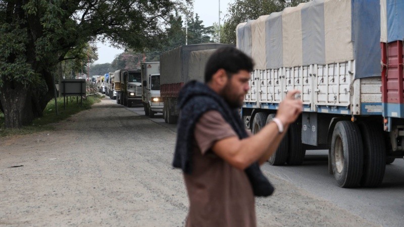 Un periodista local registra el paso intenso de los camiones. 