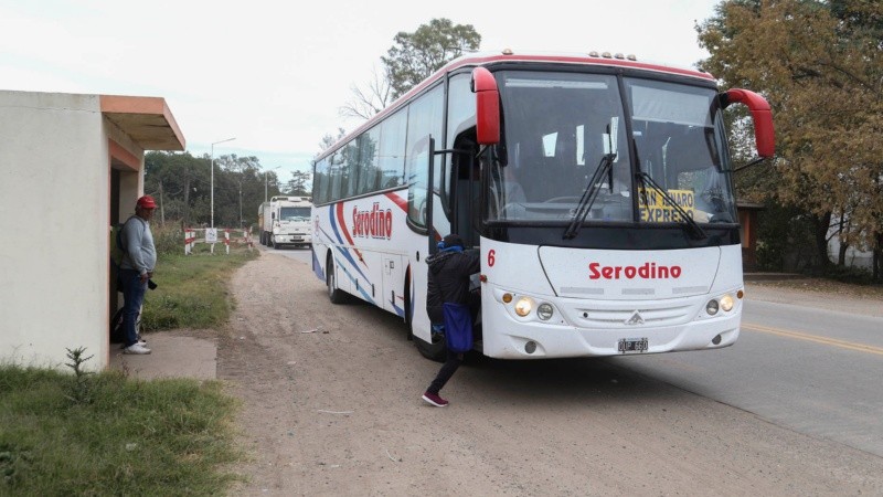 Tras una larga espera, una mujer toma el colectivo Serodino sobre la ruta 91.