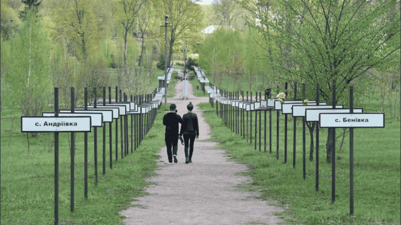 Turistas caminan por un paseo con rótulos de las ciudades y pueblos evacuados tras el desastre.